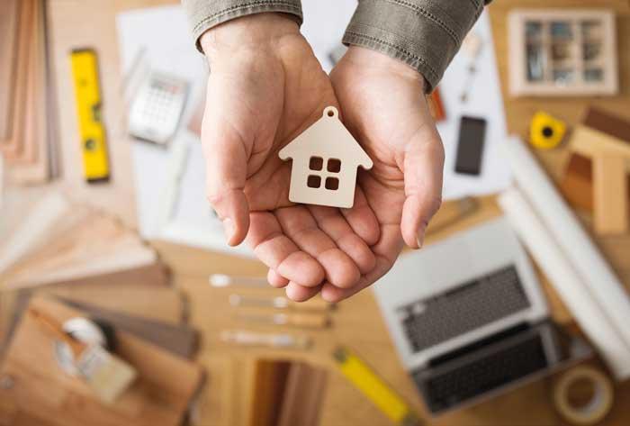 clasped hands with a wooden house shape keyring 